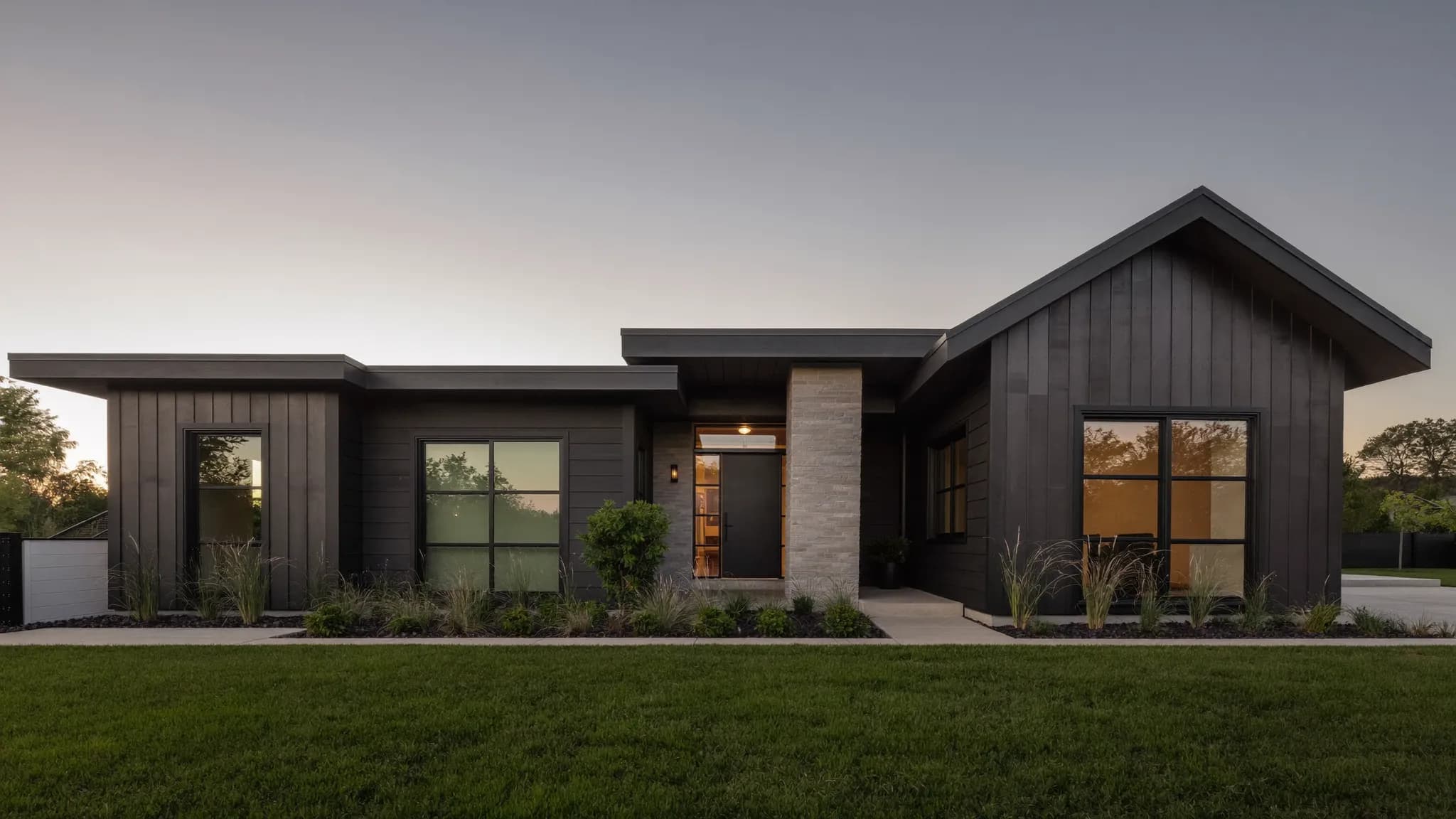 A newly built modern ranch home with a covered entry in soft afternoon light