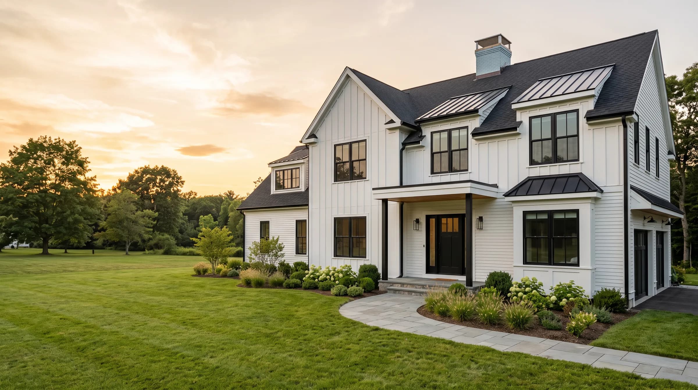 A newly completed modern colonial home with dark trim on a clear afternoon